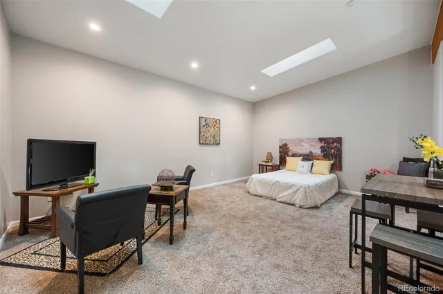 a bedroom with a bed a table and a potted plant