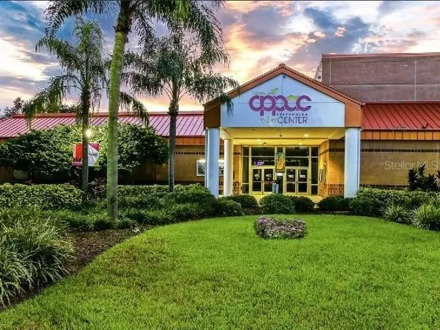 a view of a house with a yard and potted plants