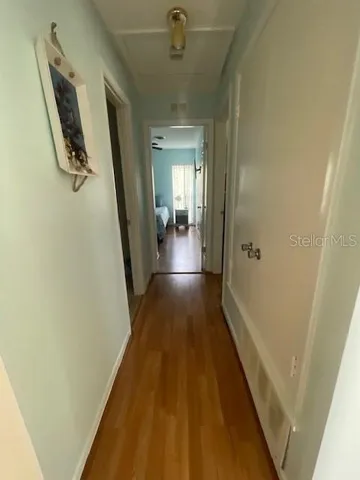 a view of a hallway with wooden floor and staircase