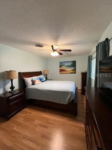 a bedroom with a bed and a flat tv screen on a dresser