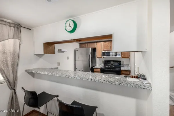 a kitchen with stainless steel appliances granite countertop a sink and a refrigerator