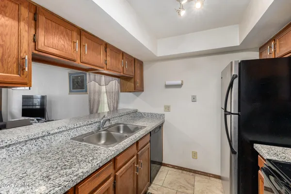 a kitchen with stainless steel appliances granite countertop a refrigerator a sink and dishwasher