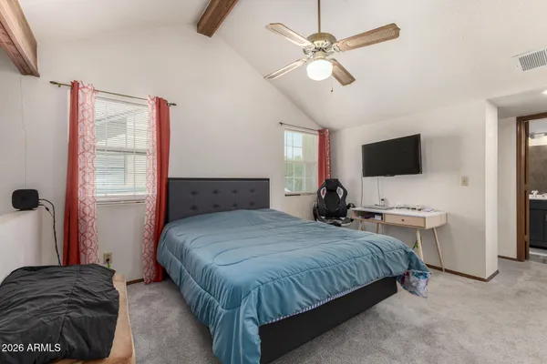 a bedroom with a bed and a flat tv screen on the dresser