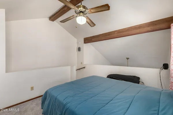 a bedroom with a large bed and a ceiling fan