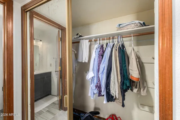 a view of walk in closet with clothes and shoes