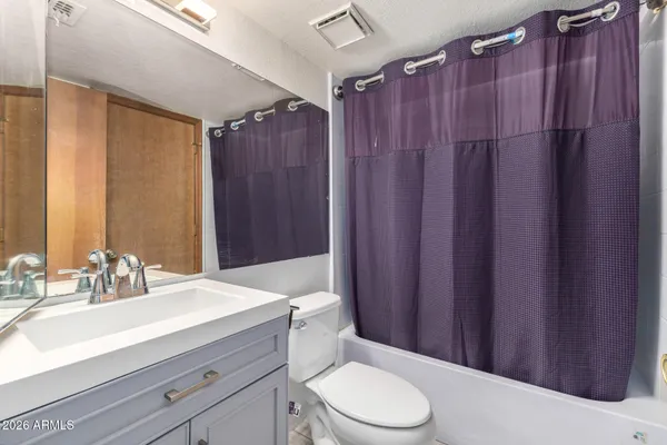 a view of a hallway with a livingroom and a bathroom with a sink