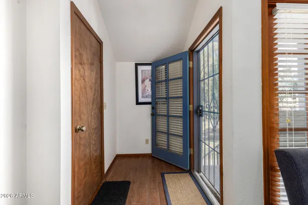 a view of a hallway with wooden floor and stairs