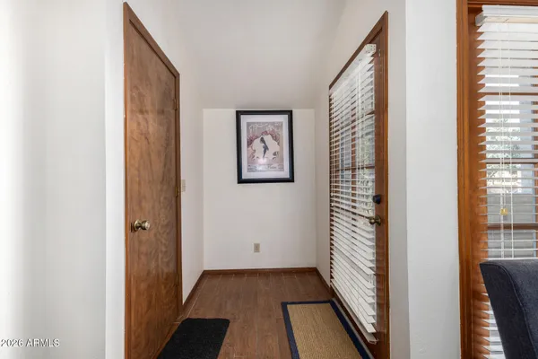 a view of a hallway with wooden floor and a bathroom
