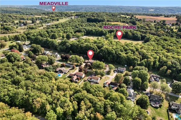 an aerial view of a residential houses with outdoor space and swimming pool