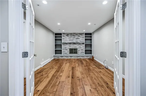 a view of a hallway with wooden floor and a fireplace
