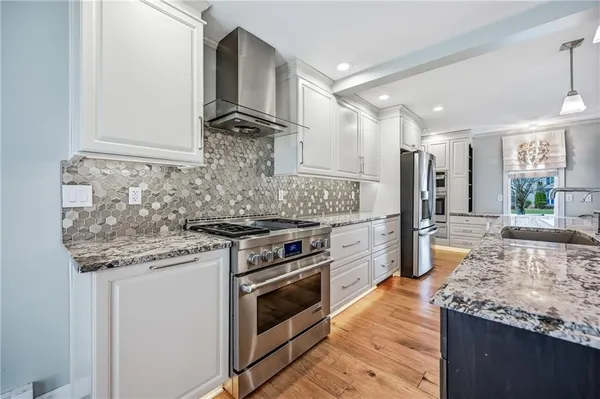 a kitchen with stainless steel appliances granite countertop a stove and a sink
