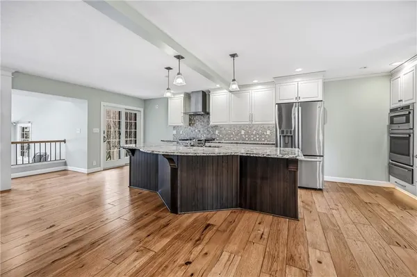 a large kitchen with a wooden floor and kitchen view