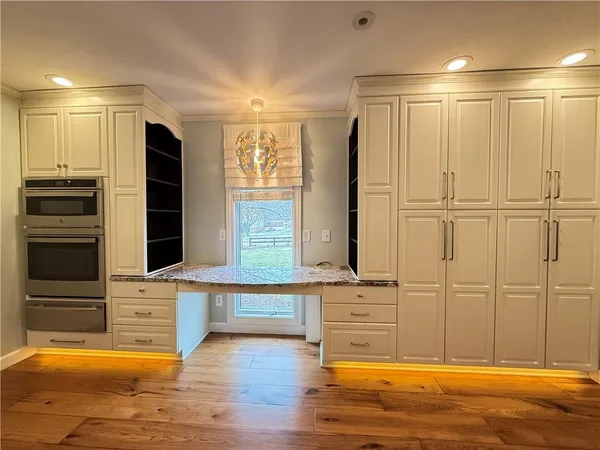 a view of a livingroom with an empty space and kitchen space