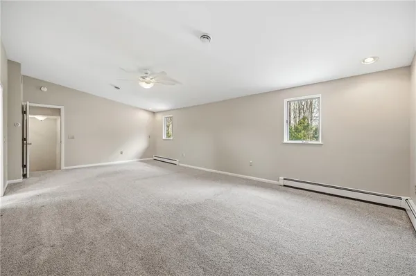 an empty room with windows and ceiling fan