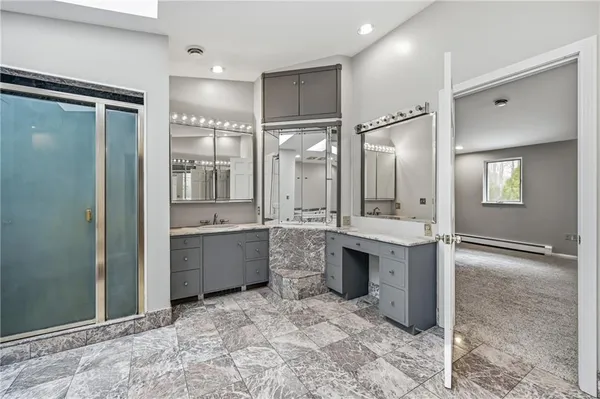 a bathroom with a double vanity sink mirror and shower
