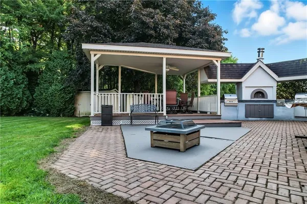 a view of a patio with couches table and chairs with wooden fence and plants
