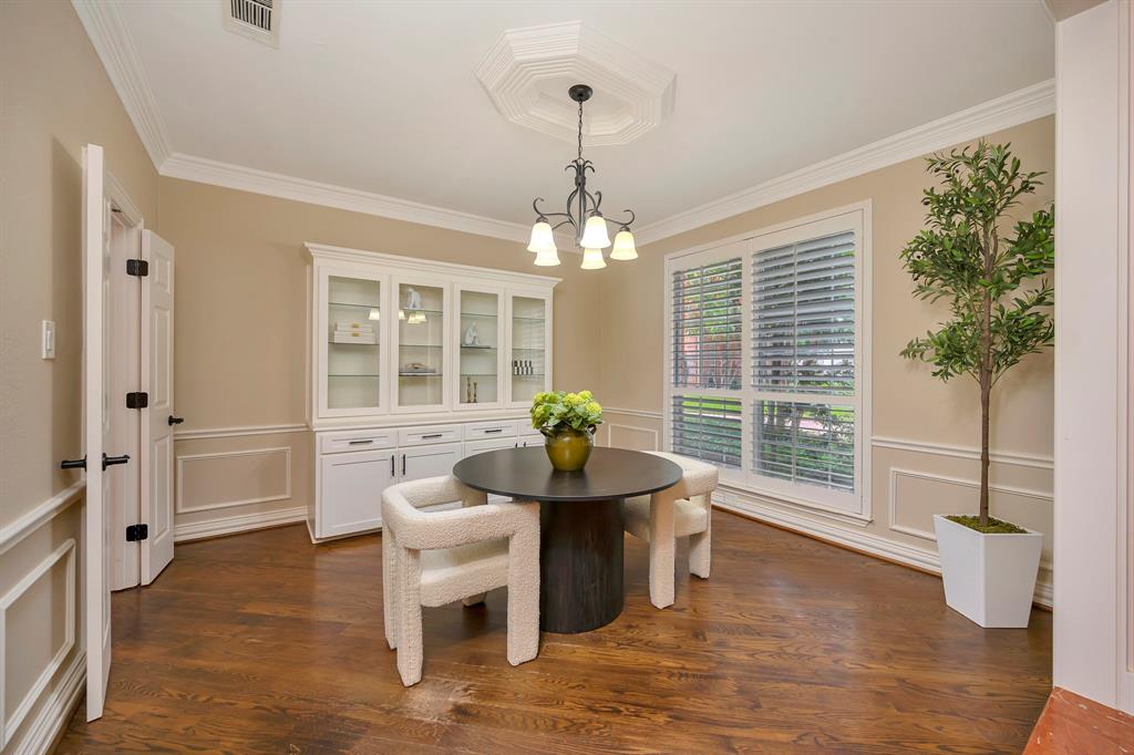 4008 Ramsgate Court Colleyville, TX 76034 - Photo 17 of 33 Formal dining room featuring wood-finish flooring, wainscoting, crown molding, and a built-in white china cabinet with glass doors
