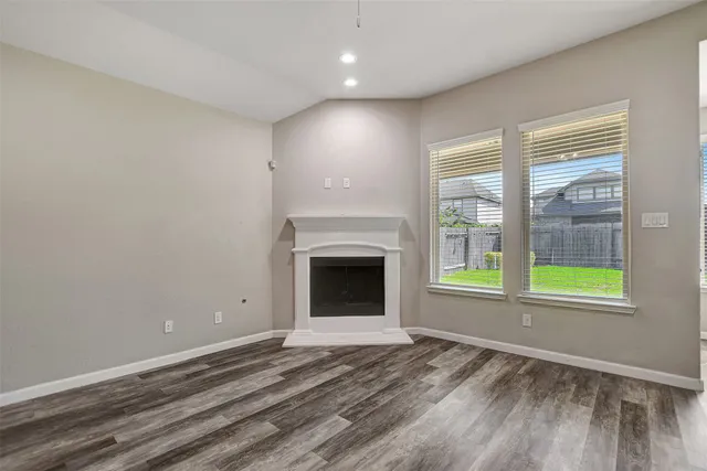 a view of an empty room with a fireplace and a window