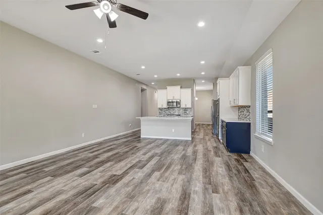 a view of an empty room with a window and fireplace