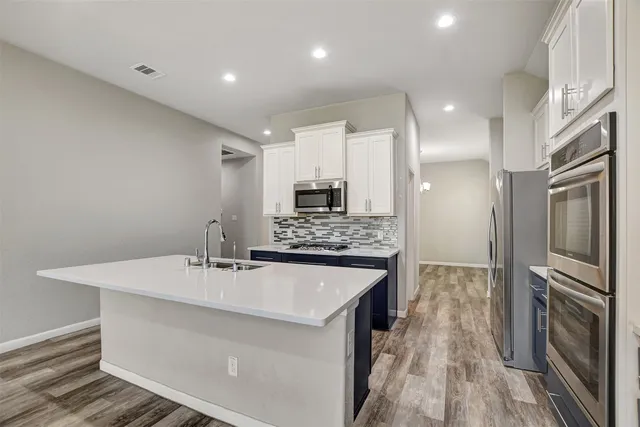 a large kitchen with a large counter top appliances and cabinets