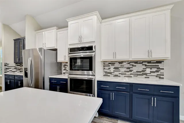a large kitchen with stainless steel appliances granite countertop a stove refrigerator and a sink