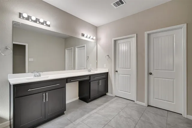 a spacious bathroom with a tub sink shower and mirror