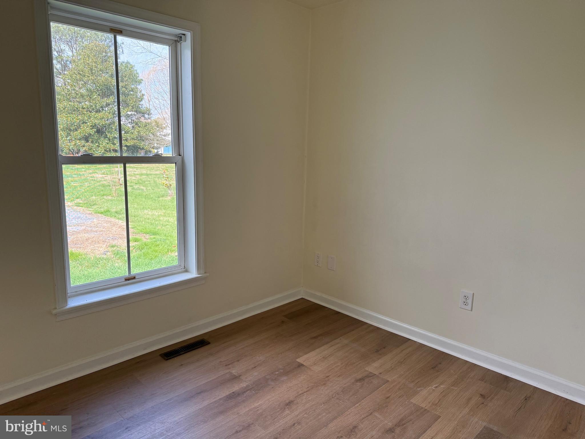 6937 Bellevue Road Royal Oak, MD 21662 - Photo 7 of 9 an empty room with wooden floor and windows