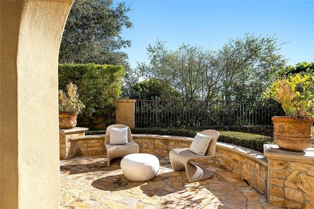 a view of a patio with table and chairs potted plants and large tree