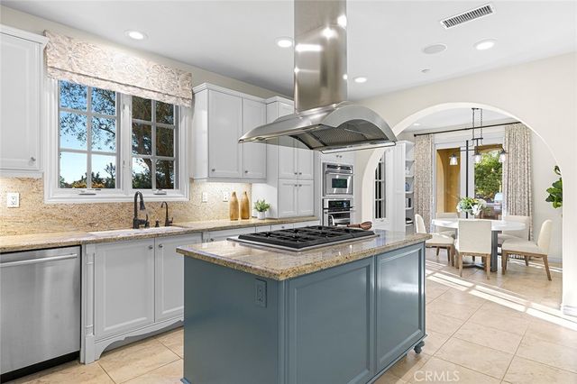 a kitchen with stainless steel appliances granite countertop a sink a stove and a large window