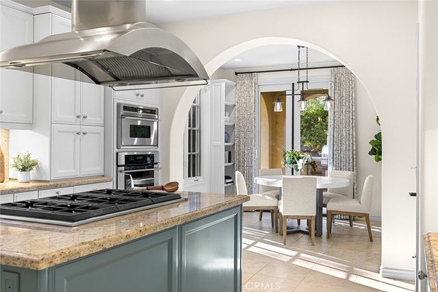 a kitchen with stainless steel appliances granite countertop a stove and a view of living room