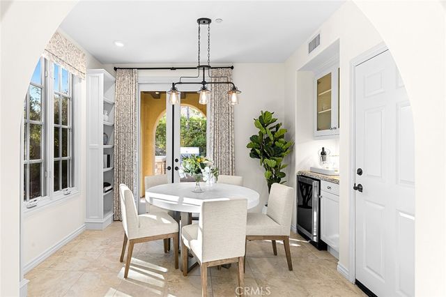 a dining room with furniture potted plants and wooden floor