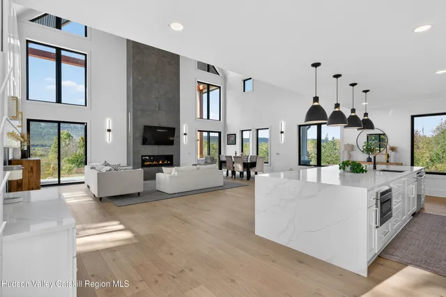 a living room with furniture fireplace and a large window