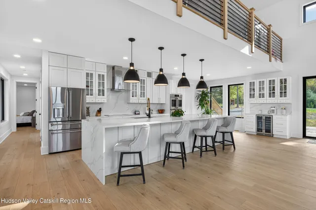 a kitchen with stainless steel appliances a table chairs refrigerator and cabinets