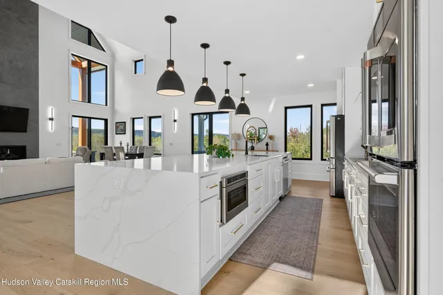 a large kitchen with stainless steel appliances kitchen island granite countertop a large counter top and couches