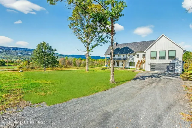 a view of an house with a backyard and trees