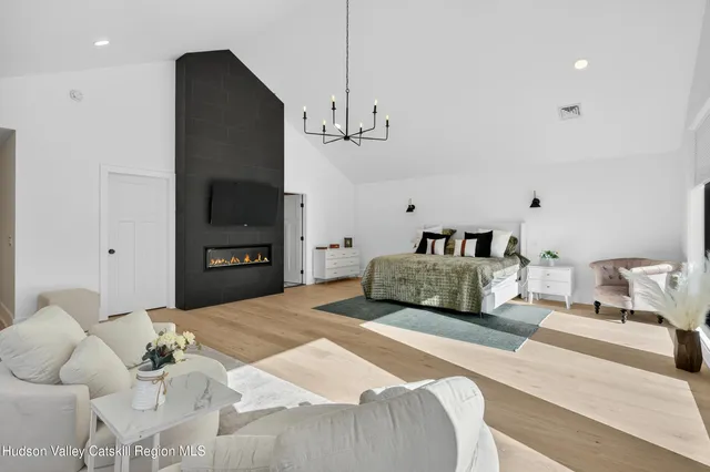 a bedroom with a bed a chandelier and a flat screen tv