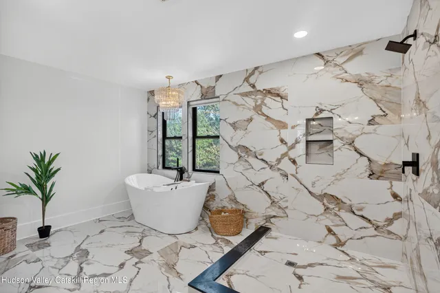 a bathroom with a tub sink and mirror