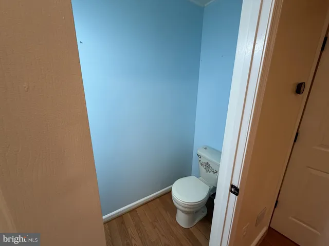 an empty room with chandelier fan and windows