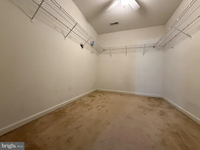 a view of an empty room with a chandelier fan