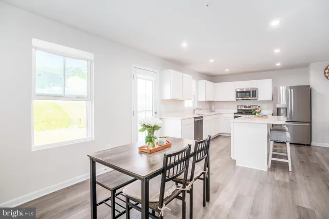 a kitchen with kitchen island white cabinets and stainless steel appliances