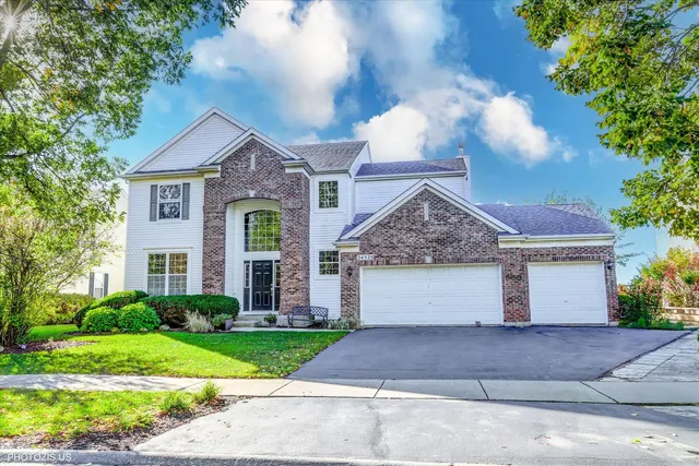 a front view of a house with a garden and plants
