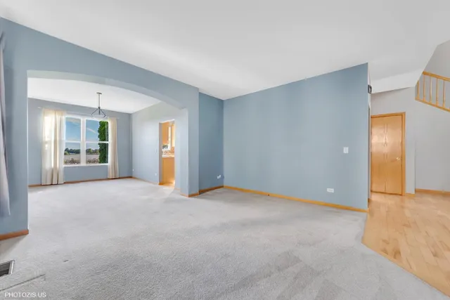 an empty room that has a window and a refrigerator