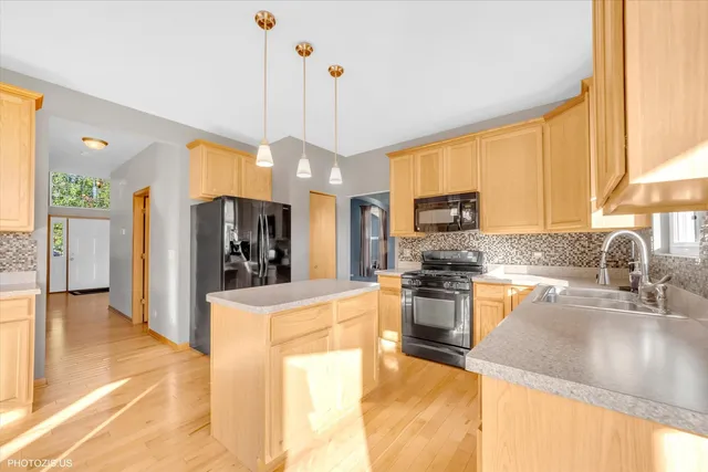 a kitchen with stainless steel appliances granite countertop a sink a stove and a refrigerator