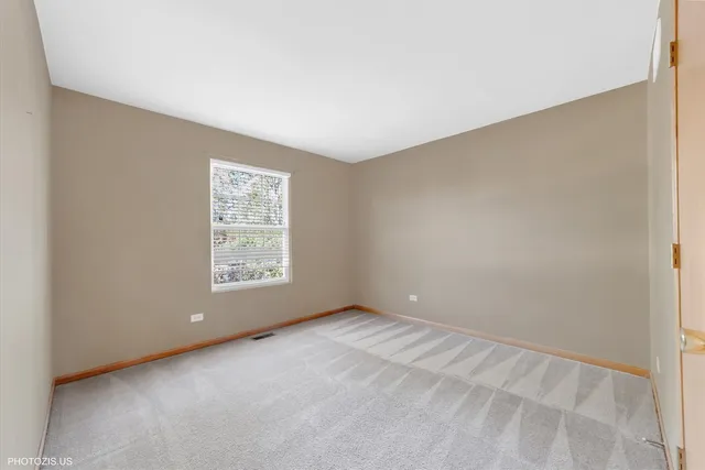 an empty room with a fireplace and window