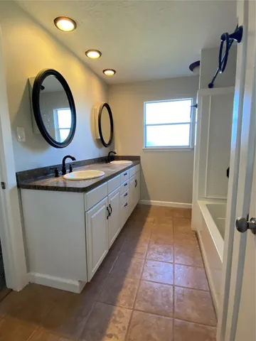 a bathroom with a double vanity sink and a mirror