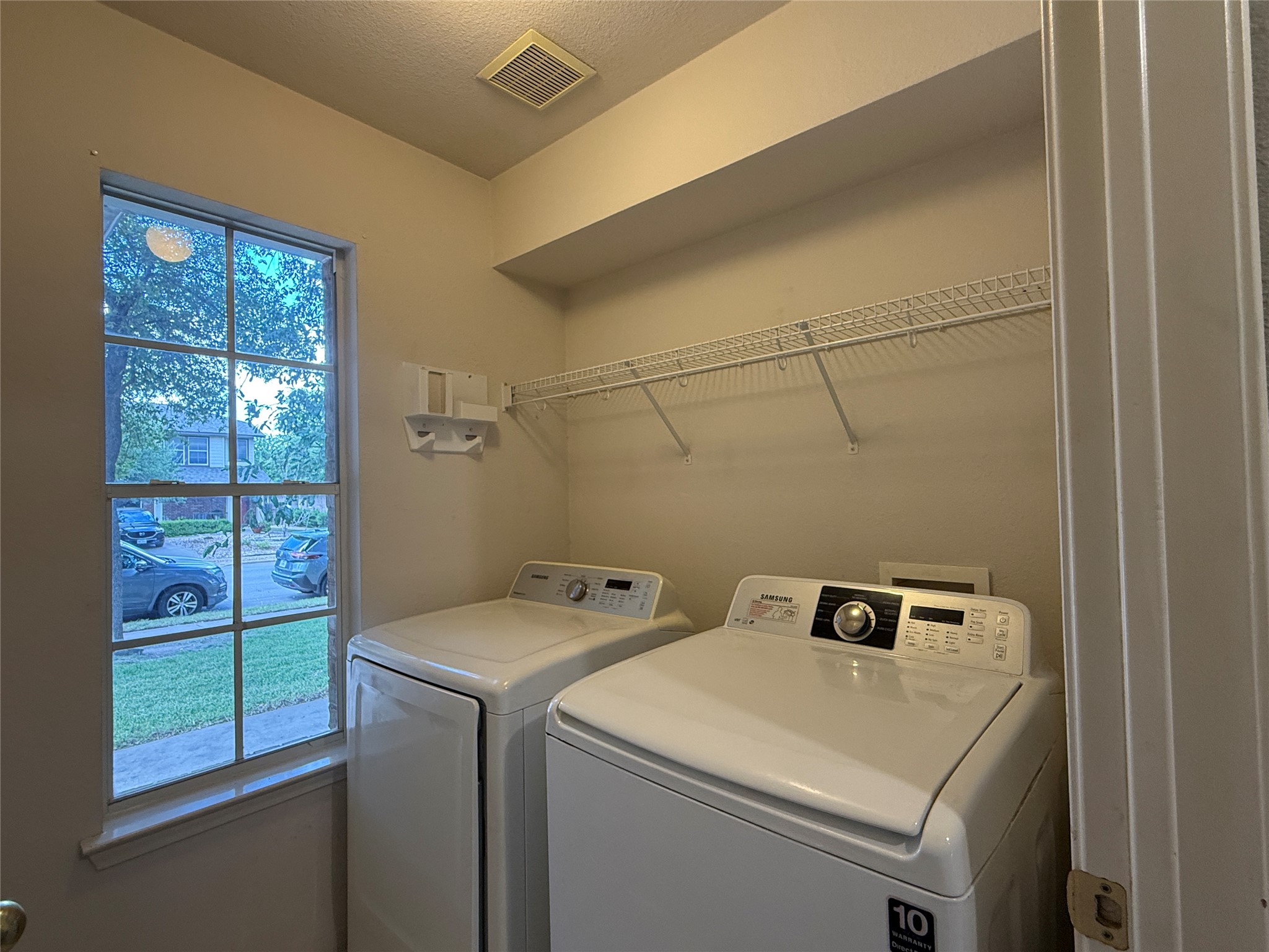 2120 Jester Farms Road Round Rock, TX 78664 - Photo 23 of 28 Efficient laundry area features a window and convenient overhead shelving for storage.