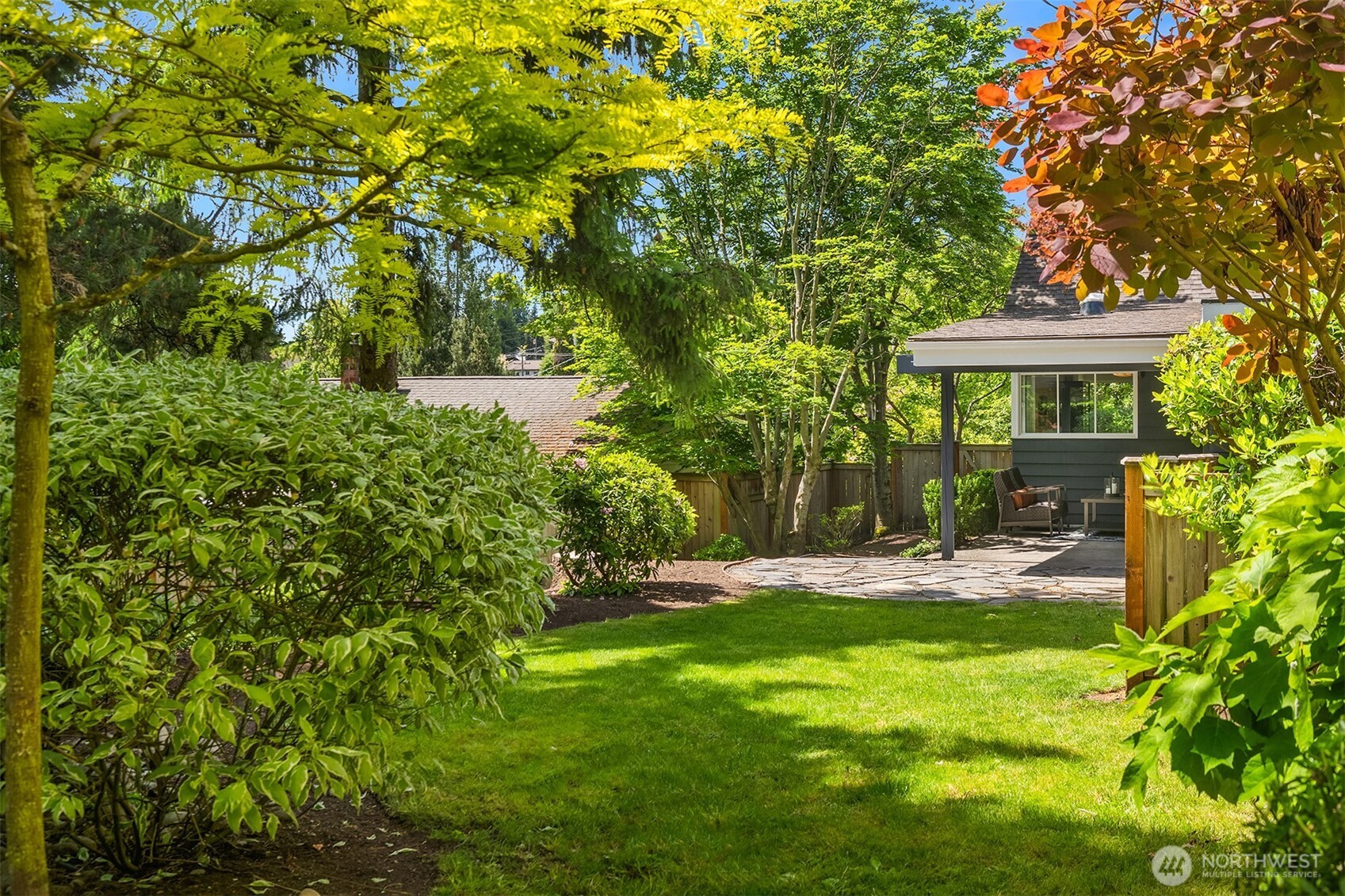 6034 40th Avenue Northeast Seattle, WA 98115 - Photo 29 of 40 a view of a yard in front of a house with plants and large trees