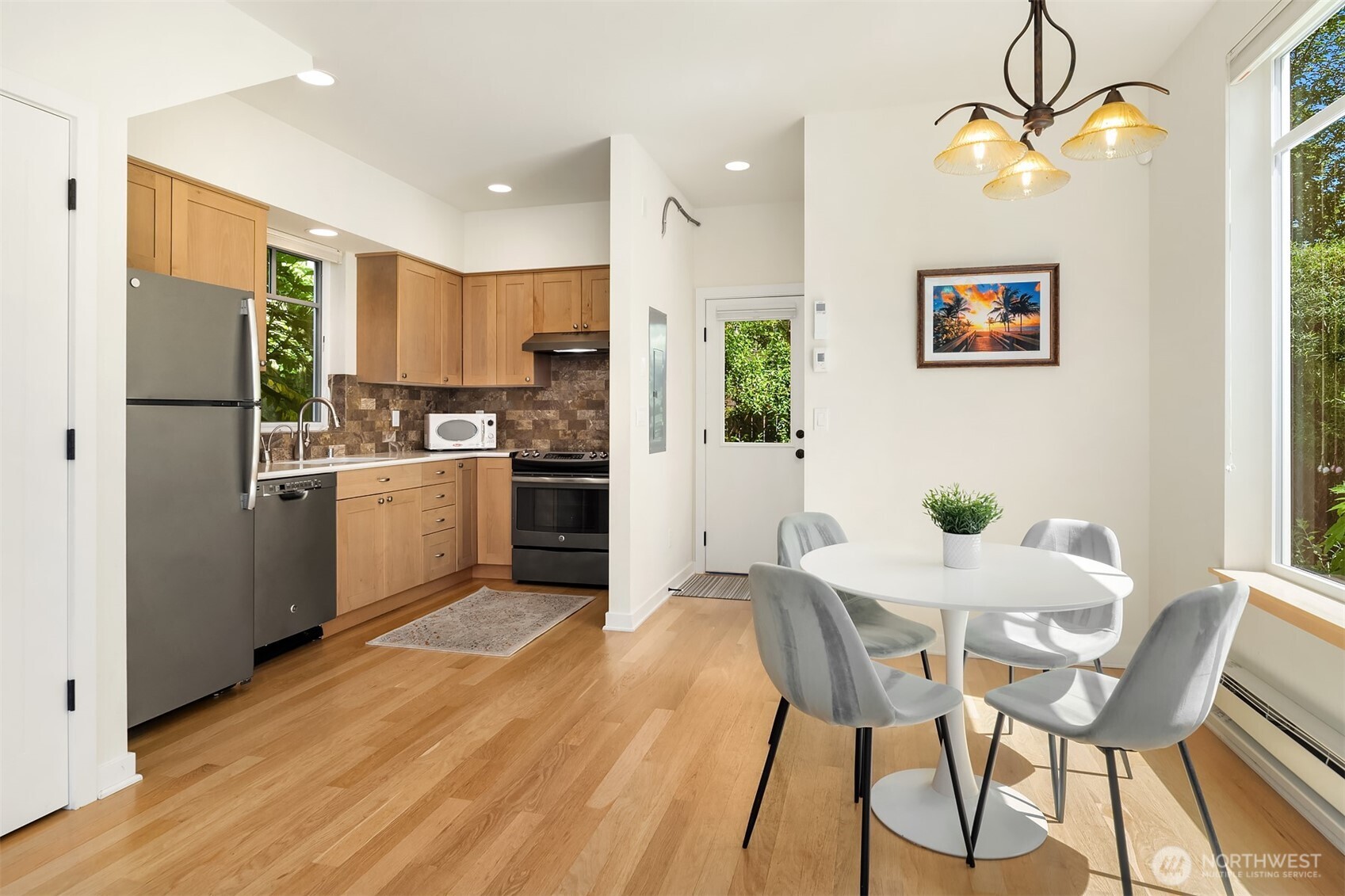 6034 40th Avenue Northeast Seattle, WA 98115 - Photo 33 of 40 a kitchen with a table chairs refrigerator and a sink