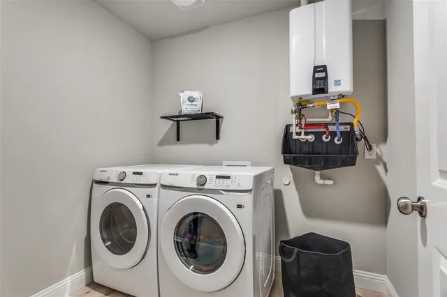 a utility room with dryer washer and a view of living room
