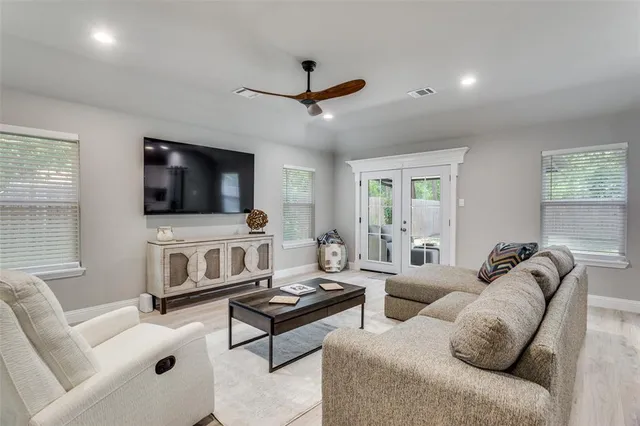 a living room with furniture a flat screen tv and a window